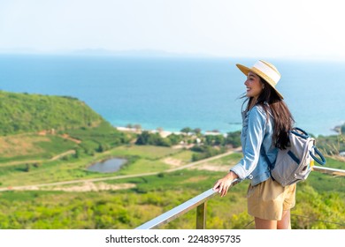 Asian woman with backpack solo travel on tropical island mountain peak in summer sunny day. Attractive girl enjoy and fun outdoor lifestyle looking beautiful nature of ocean on beach holiday vacation. - Shutterstock ID 2248395735