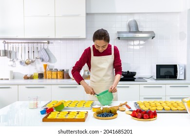 Asian Woman Bakery Shop Owner Preparing Bakery In The Kitchen. Adult Female Making Whipping Cream Cheese From Fresh Milk. Small Business Entrepreneur And Indoor Activity Lifestyle Baking Concept