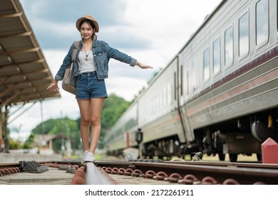 Asian woman balancing on the train rail.  Attractive young woman walking outdoors. - Shutterstock ID 2172261911