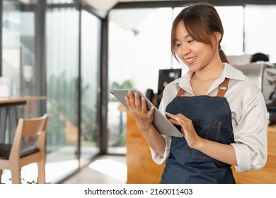 Asian woman barista holding digital tablet for checking order from customer at coffee cafe shop background , SME business concept - Powered by Shutterstock