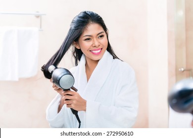 Asian Woman In Bathroom Drying Hair With Blow Dryer