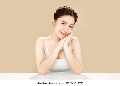 Asian woman with a beautiful face and fresh, smooth skin. Cute female model with natural makeup and sparkling eyes is posing on white isolated background.