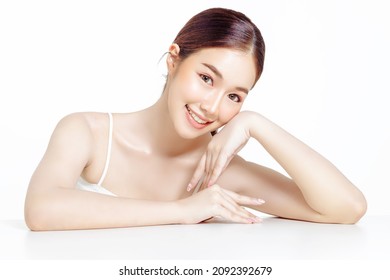 Asian woman with a beautiful face gathered in a brown ponytail and clean fresh smooth skin. Cute female model with natural makeup and sparkling eyes on white isolated background.