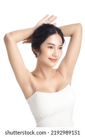 Asian Woman With A Beautiful Face And Perfect Clean Fresh Skin. Cute Female Model Rising Arm Show Her Armpit On White Isolated Background. Facial Treatment, Cosmetology, Beauty Concept.