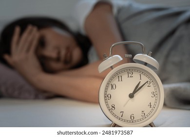 asian woman in bed late trying to sleep suffering insomnia, sleepless or scared in a nightmare, looking sad worried and stressed. Tired and headache or migraine waking up in the middle of the night. - Powered by Shutterstock