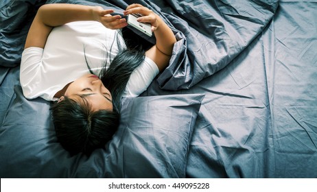 Asian Woman In Bed Watching The Phone