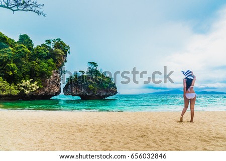 Asian woman in bikini her hand holding big hat looking destinations beach and small island, Koh Pak Bia island, Separated sea, Andaman sea, Krabi province, Thailand