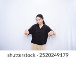 Asian woman in black dress expression pointing down on white background