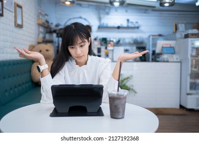 Asian Woman with black hair frustrated with work.Poor communication at work.A beautiful Asian woman is working online in a cafe.Business woman dissatisfied at work.business woman confusion with work.