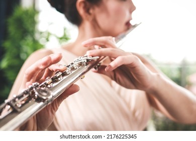 Asian Woman Blowing The Flute, A Universal Classical Instrument. The Concept Of A Classical Music School. Music Teacher