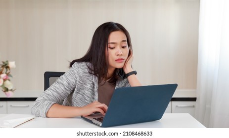 Asian Woman Bored At Work Looking At Her Computer Screen. Burnout Syndrome Low Power Worker Concept. Exhausted Business Woman Feel Unmotivated Unwilling To Work, Distracted Taking Break