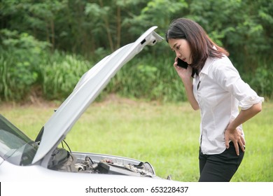 Asian Woman With A Broken Car With Open Hood.