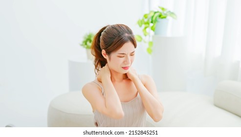 Asian Woman With Brunette Ponytail Unhappy Touch Her Neck Feeling Pain And Sore