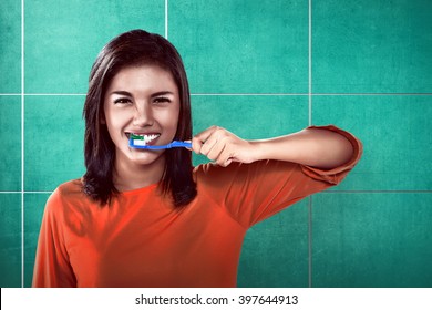 Asian Woman Brushing Her Teeth On The Bathroom