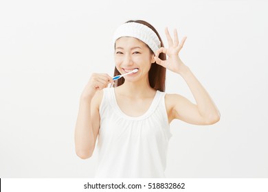 Asian Woman Brushing Her Teeth