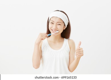 Asian Woman Brushing Her Teeth