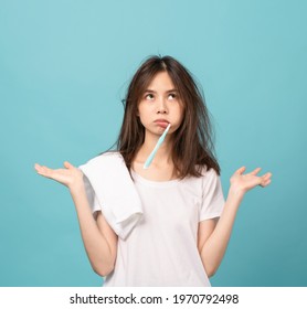 Asian Woman Brushing Teeth And Towel On The Shoulder On Blue Background, Concept Oral Hygiene And Health Care.