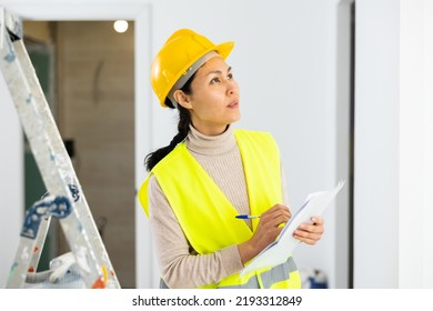 Asian Woman Builder Checking Project Documentation While Working In Apartment.