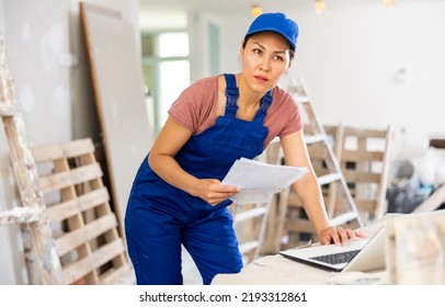 Asian Woman Builder Checking Project Documentation And Using Laptop While Working In Apartment.