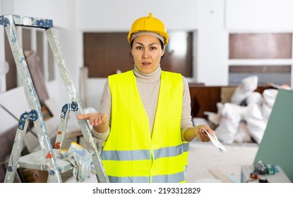 Asian Woman Builder In Hardhat And Yellow Vest, Holding Bunch Of Cash, Frustrated By Her Salary.