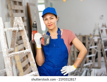 Asian Woman Builder Holding Drill, Smiling And Looking At Camera. Repair Works In House.