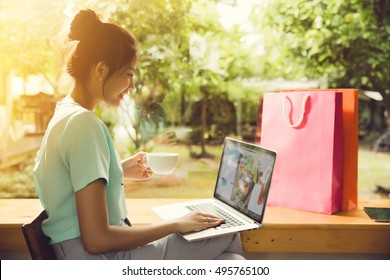 Asian Woman Buying From An Online Store. She Was At A Coffee Shop