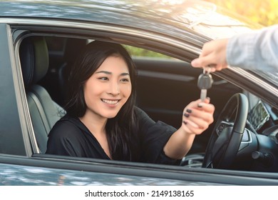 Asian Woman Buying Or Renting Rental New Car Owner Receiving Car Key From Sales Seller, Taking And Passing Driving License Examination Test, Happy Cheerful Smiling Excited Salesman Sold Car Dealership