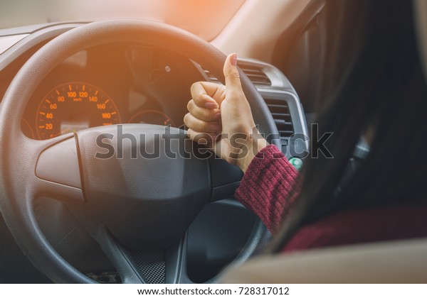Asian woman in car making hand thumbs up  Like ,\
Ok sign ready for driving\
