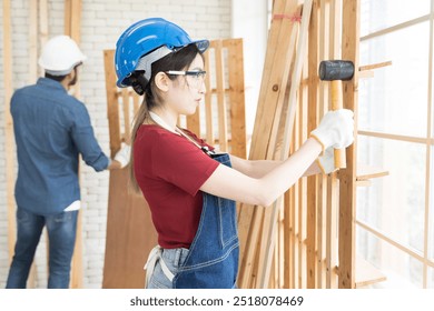 Asian woman carpenter working and building furniture at wood workshop. Asian joiner woman making furniture at furniture workshop - Powered by Shutterstock