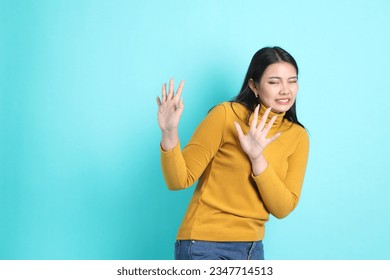 The Asian woman in casual clothes standing on the green background. - Shutterstock ID 2347714513