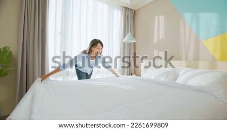 asian woman changes bed quilt in bedroom and it is fresh and comfortable