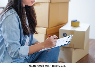 Asian Woman Checking And Packing The Carton Box Prepare To Move To New House Relocation Shipping Or Check Goods Package Before Delivery To Customer From Online Shopping By Checklist