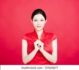 Asian woman in chinese cheongsam with congratulation gesture