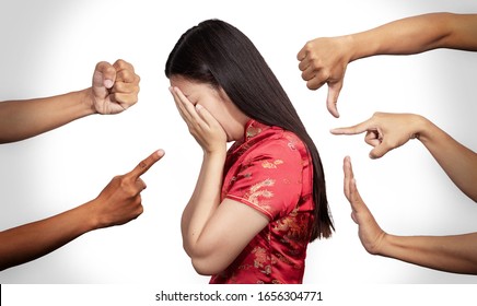 Asian woman in Chinese costume covered her face with regret for being racism and hate surrounded by hands mocking her, scoffing in the outbreak situation of Coronavirus 2019 infection or Covid-19