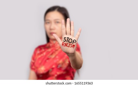 Asian woman in Chinese costume doing stop gesture with palm hand with message stop racism. warning expression with negative and serious gesture.