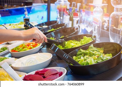 Asian Woman Choosing Vegetable Ingredients At Salad Bar Buffet Restaurant