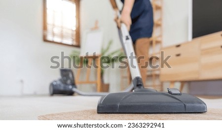 Asian woman clean in living room at home. Housekeeper or maid cleaner feel happy use vacuum cleaner to clean