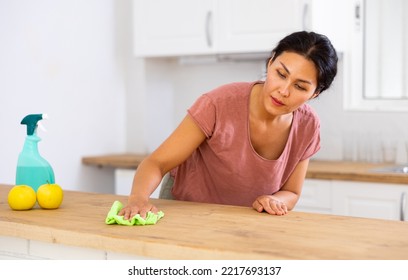 Asian Woman Cleaning Dinning Table With Rag In Kitchen At Home.