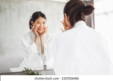 Asian woman cleaning face front of mirror, skin care and cosmeti