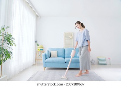 Asian woman cleaning at the living room