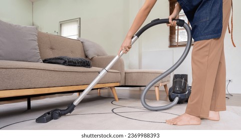 Asian woman cleaning in living room at home. Housekeeper or maid cleaner feel happy use vacuum cleaner to clean - Shutterstock ID 2369988393