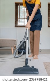 Asian woman cleaning in living room at home. Housekeeper or maid cleaner feel happy use vacuum cleaner to clean - Shutterstock ID 2369988421