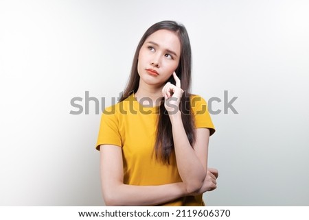 asian woman in color casual dress thinking and imagination isolated on pink background