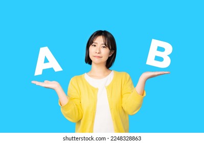 Asian woman comparing two things. - Shutterstock ID 2248328863