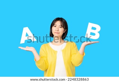 Asian woman comparing two things. ストックフォト © 