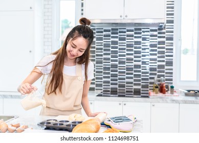 Asian Woman Cooking And Baking Cake In Kitchen Alone Happily. People And Lifestyles Concept. Food And Drink Theme. Interior Decoration Theme.