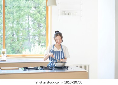 Asian Woman Cooking  At Home