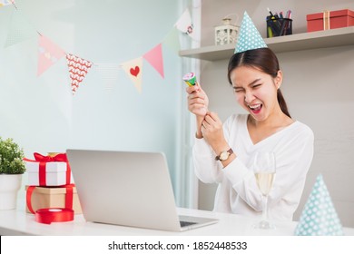 Asian woman count down and pull party popper to celebrate new year party via video call conference, new normal for birthday, Christmas and new year party at home - Powered by Shutterstock