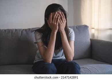 Asian woman covering her face feeling sorrow and depressed sit in the dark bedroom - Powered by Shutterstock