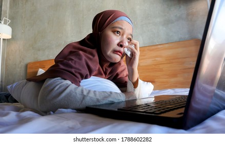 Asian Woman Crying Watching A Movie On A Laptop In Bedroom